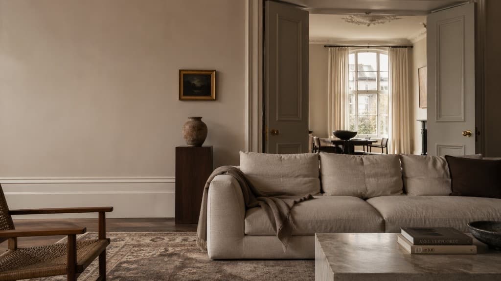 Sophisticated open-plan living and dining interior with a cream sofa, marble coffee table, and soft daylight — the kind of work Studio proposals help you win.